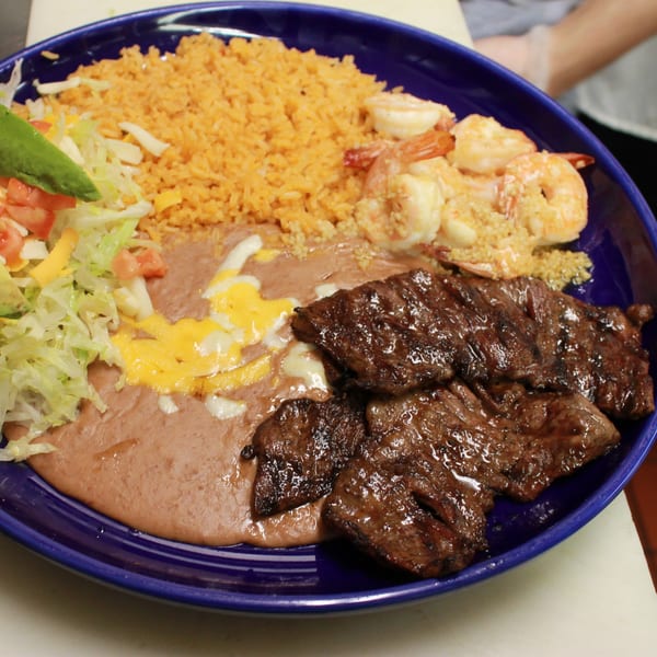 El Nopal's Mexican dish with grilled steak, shrimp, rice, refried beans, and salad.
