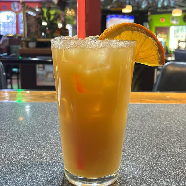 A refreshing El Nopal Mexican Restaurant margarita with a salted rim and orange slice.