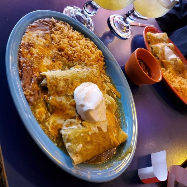 El Nopal's enchiladas with rice and beans, topped with sour cream, alongside margaritas.